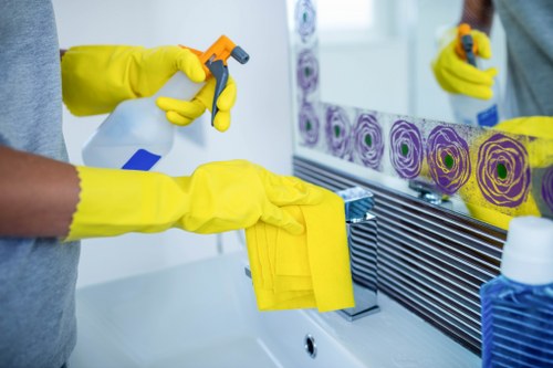 Professional cleaner tidying a short-let kitchen in Brompton